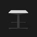 Herman Millers Nevi sittande skrivbord med svarta ben och vit topp från sidan.